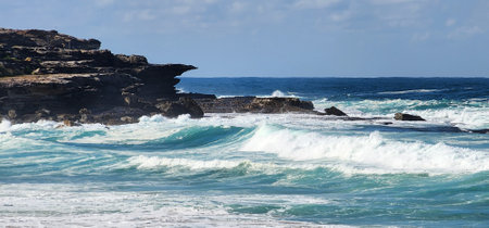Beautiful breaking waves on the rocky shore of Maroubra Beach, Sydney