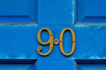 House number 90 on a blue wooden front doorの写真素材