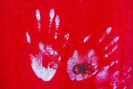 WHite handprints on a vibrant red background and the word okの写真素材