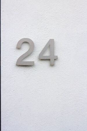 House number 24 on a white wall with black stripeの写真素材