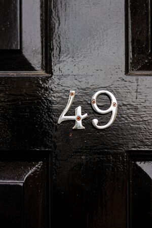 House number 49 on a black wooden front door