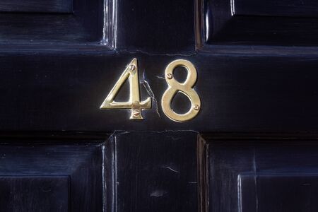 House number 48 on a black wooden front doorの写真素材
