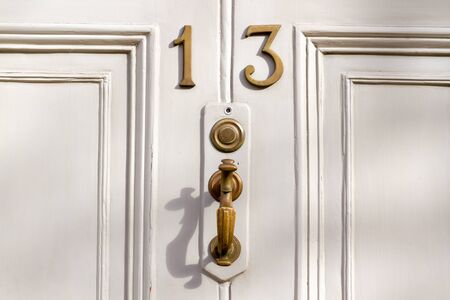 House number 13 on an elegant wooden front door in whiteの写真素材