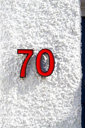 House number 70 on a white plaster wallの写真素材