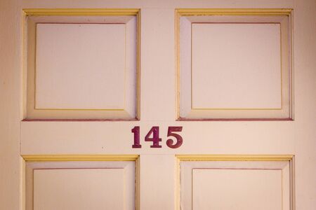 House number 145 on a traditional British wooden front door