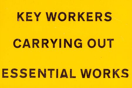 London, U.K. - 14 May 2020: A roadsign alerts people to key workers carrying out essential worksの写真素材