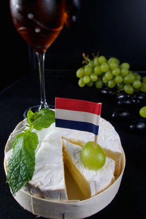 Delicious camembert cheese with glass of wine and grapesの写真素材