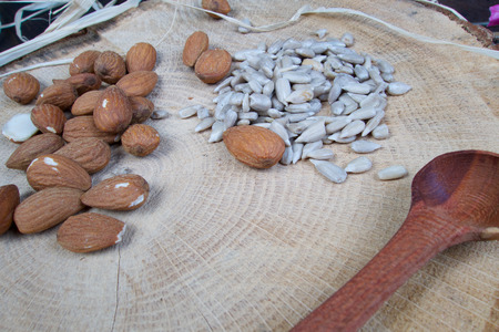 Almond and sunflower healthy seeds on wooden board with patternの写真素材