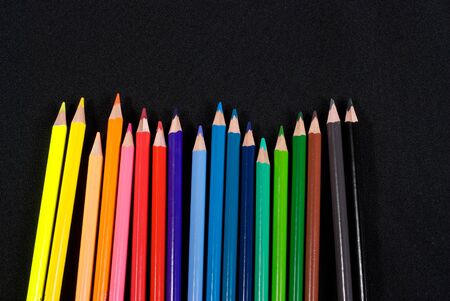 Business concepts: colourful pencils in the hand on black backgroundの写真素材