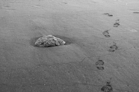 Footprints on the black sand beachの写真素材
