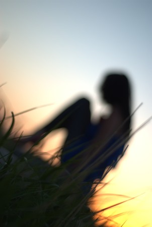 Rear view of beautiful sexy young woman surfer girl in bikini with white surfboard on a beach at sunset or sunriseの写真素材