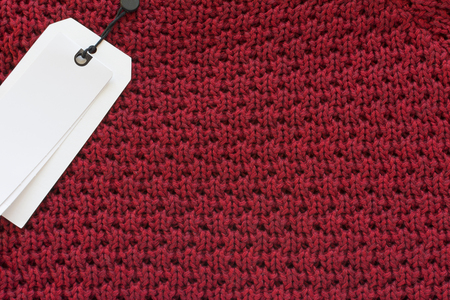 Price tag sale label on red knitted wool fabric texture background for shoppingの写真素材