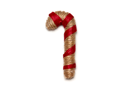 Christmas cane wrapped with threads and a red ribbon on a white background. Design element for christmas and new year.の写真素材