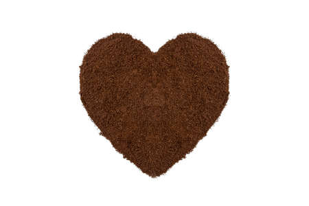 Heaps of ground roasted coffee are arranged in a heart shape. isolated on a white background.の写真素材
