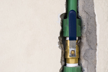 Opened brass ball valve connected to PPR pipe inside wall, clean water pipe in household and industrialの写真素材