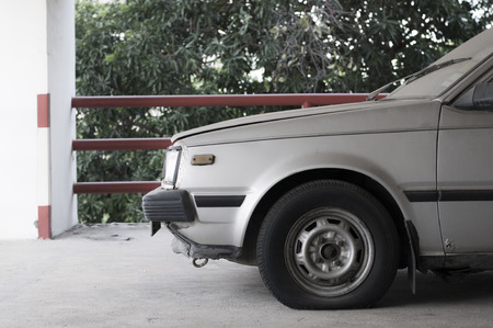 Old style scene of abandoned dusty old japanese car in car parkの写真素材