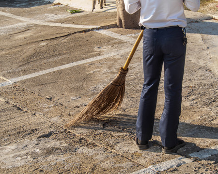 the man holding a broom sweeper cement floorの写真素材