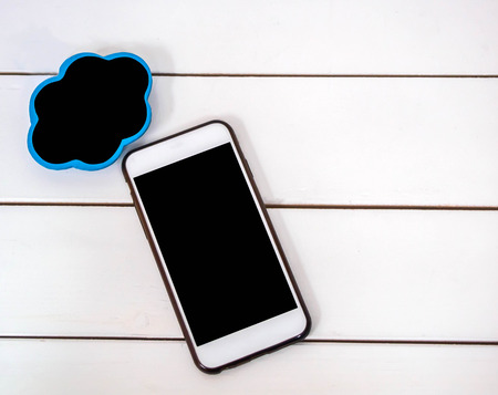 mobile phone on white chair background with small board cloudt , black space for insert text or...