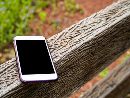Cell phone placed on a wooden balcony