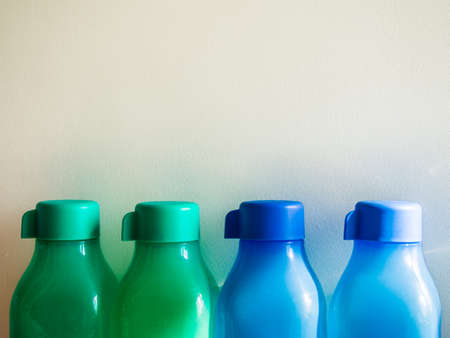 colorful plastic water bottles on the white wallの写真素材