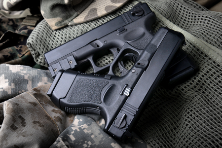 Pistal automatic short hand gun in the  US army prop background photo in lowlighting and dark shadow...
