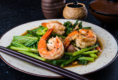 Chinese kale or broccoli fried with soy sauce and big shrimps in Chinese style.の写真素材