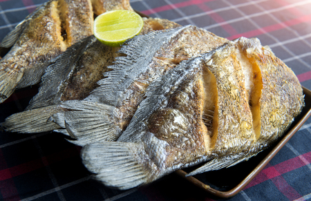Fried salted dried damsel fish servr with lemon in Thai style.