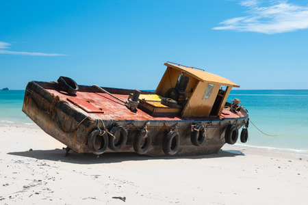 Out focus of old and rusty vintage boat on the beach with outdoor sun lighting.の写真素材