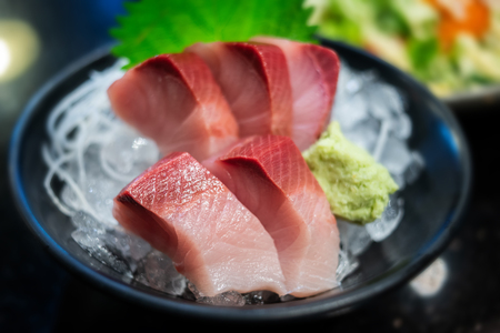 Raw Yellow tail fish or Hamachi sashimi in Japanese food name photo with very low lighting and wide aperture.の写真素材