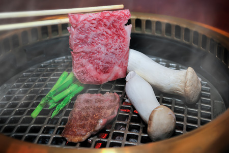 Japanese beef grill with chopstick in charcoal fire.の写真素材