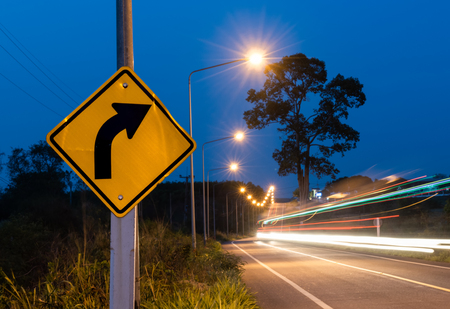 Turn right street sign with car ligh line motion in twilight sky time.の写真素材