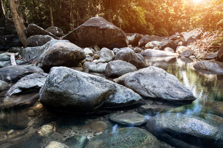 Stones and grop of  nature rocks with forest water in nature scape dark and low lighting.の写真素材