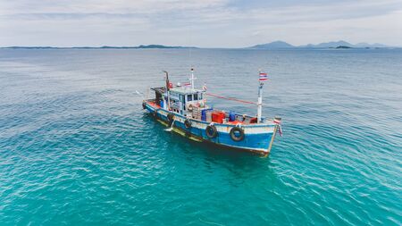Top view from sky of group of wooden fishery boat at the sea marina with day lighting.の写真素材