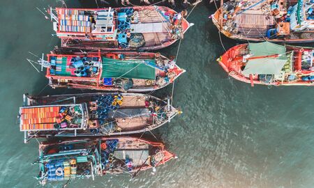 Top view from sky of group of wooden fishery boat at the sea marina with day lighting.の写真素材