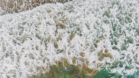 Top view from sky of sea wave and sand beach landscape with outdoor sun lighting.
