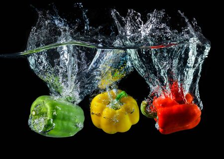 Water droping bell pepper or paprika with splashing water in black background.の写真素材