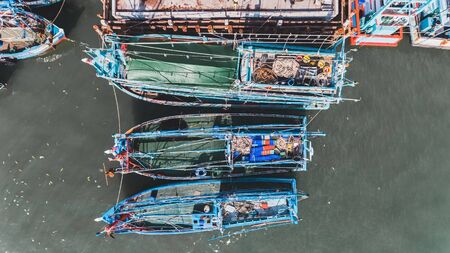 Top view from sky of group of wooden fishery boat at the sea marina with day lighting.