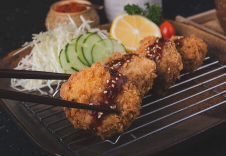 Japanese deep fried pork chop or menchikatsu style with sauce and vegetable salad set.の写真素材