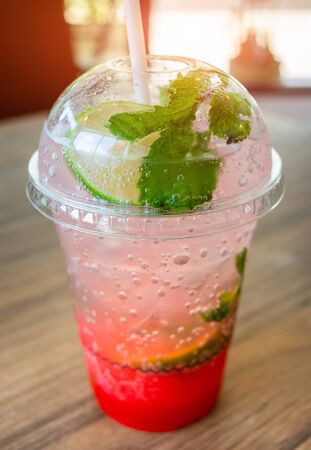 Ice soda sweet drink in plastic glass with in door low lighting.の写真素材