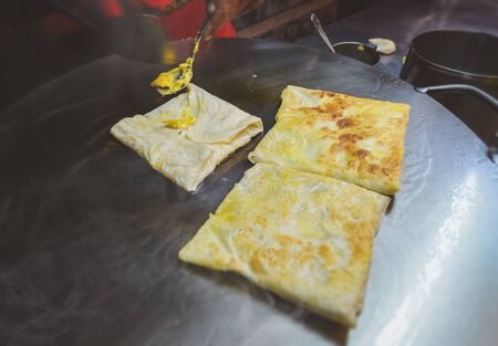 Indian street food roti sweet snack on the iron plate with night lighting.の写真素材