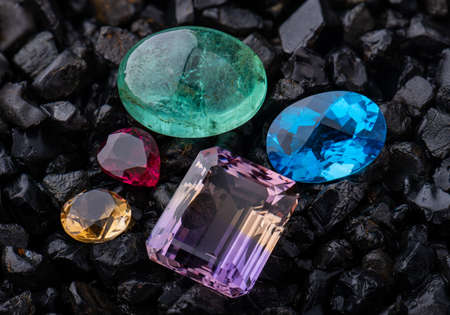 Emerald gemstone and blue quartz with dark rock background.の写真素材