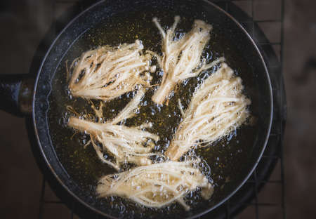 Frying crispy enoki mushroom with cooking oil.の写真素材