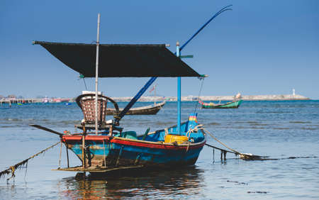 Fishery wooden boats with outdoor sun lighting and dark cloud sky.の写真素材