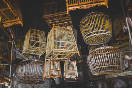 Bamboo basketry bird cage stock shop with indoor low lighting.の写真素材