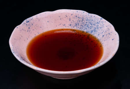 Soy bean sauce Japanese shoyu in asian style cup with black background.の写真素材