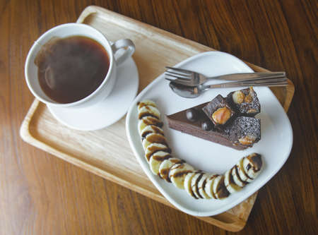 Brownies chocolate cake and  hot tea with indoor morning lighting.の写真素材