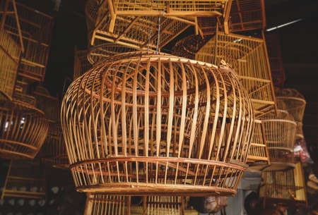 Bamboo basketry bird cage stock shop with indoor low lighting.