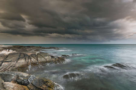 The sea rock in rainy season dark clouds with low lighting.の写真素材