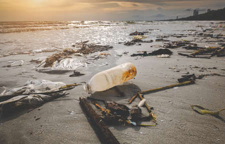 Dirty waste plastic garbage on the beach with outdoor sun low lighting.の写真素材
