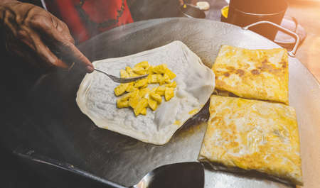 Indian street food roti sweet snack on the iron plate with night lighting.の写真素材